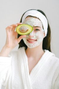 Focused woman engaged in a skincare world, applying products to her face while following a step-by-step regimen for healthy and radiant skin.